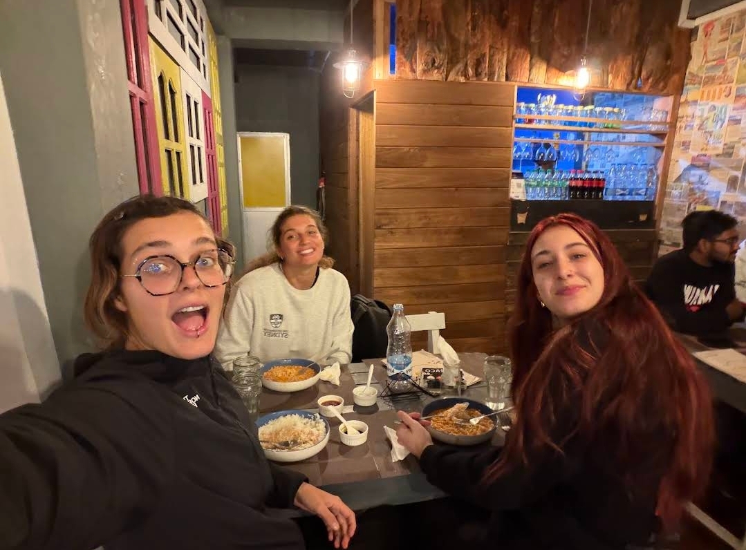 Friends sharing plates of rice and curry inside Drizzle Café